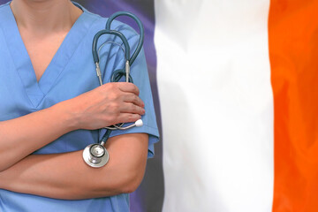 Female surgeon or doctor with stethoscope in hand on the background of the France flag. Surgery concept in France