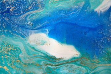 Gold and light blue mixed inks spilled background. Turquoise texture.