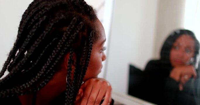 Adolescent teenage girl looks at herself in mirror