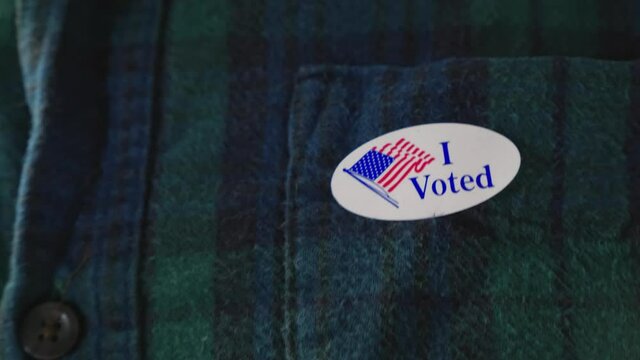 Man puts I Voted Sticker on Clothing After voting in American Election
