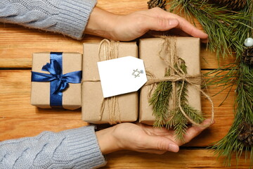 Hanukkah celebration with gift box. Happy Hanukkah. Woman holding a gift with a postcard with a Star of David. Space for text, felicitation.