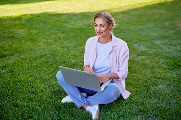 Businesswoman sitting grass summer park using laptop Business persone working remote. Outdoors