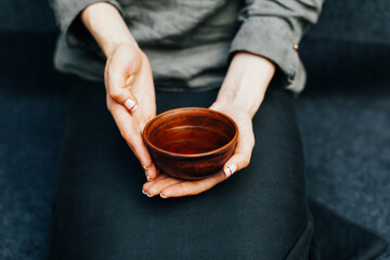 Woman offers hot tea in a vintage ceramic cup.