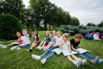 A teacher teaches a class of children in an outdoor Park. Back to school, learning during the pandemic