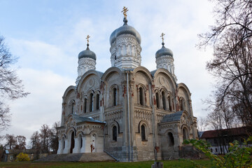 Fototapeta na wymiar White stone church with silver domes in russian village Sergeevo in sunny autumn day