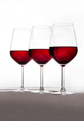 Three crystal glasses in harmony and full of wine on a white background