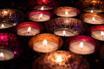 Warm, bright candles in small colorful bowls. Warm and cozy atmosphere.