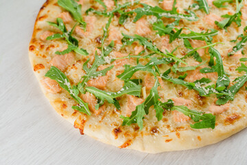 Pizza with salmon, parmesan and arugula isolated on white wooden background. Advert for social network of restaurants, caffee. Promotion for pizzeria
