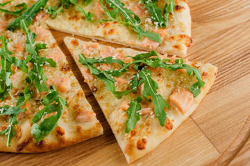 Pizza with salmon, parmesan and arugula isolated on white wooden background. Advert for social network of restaurants, caffee. Promotion for pizzeria