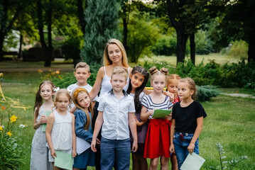 A teacher teaches a class of children in an outdoor Park. Back to school, learning during the pandemic