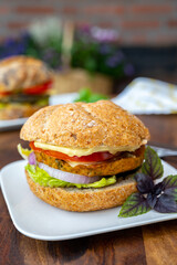 Eating of fresh and healthy vegetarian hamburgers with grilled spinach or pumpkin burgers, organic buns and vegetables