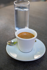 Drinking of strong black espresso coffee on outdoor terrace in cafe