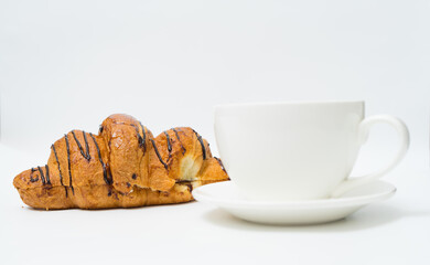 Top view or flat lay of coffee cup and croissant on white background with copy space.