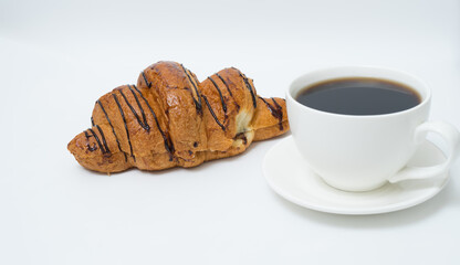 Top view or flat lay of coffee cup and croissant on white background with copy space.