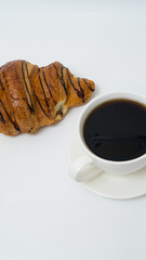 Top view or flat lay of coffee cup and croissant on white background with copy space.