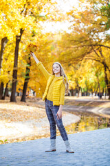 Blonde teenage girl posing in autumn park