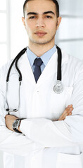 Arab doctor man is standing with crossed arms in clinic. Medicine and healthcare concept