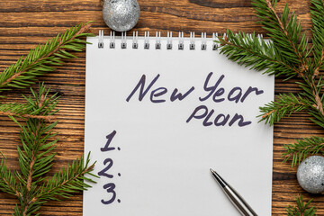 new year plan inscription in notebook with fir, spruce branches and Christmas tree toys