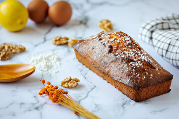 Home made nut cake and ingredients baking concept on white marble