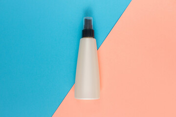 Bottle for liquid, cream, gel, lotion. Сosmetic bottle on blue and rose background. SPA cosmetic product branding mockup.
Flat lay minimalist style.