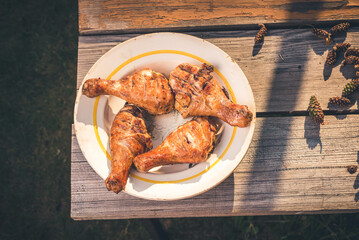 Fried chicken legs in a plate on a wooden table/Fried chicken legs in a plate on a wooden table. Top view. Sanny day.