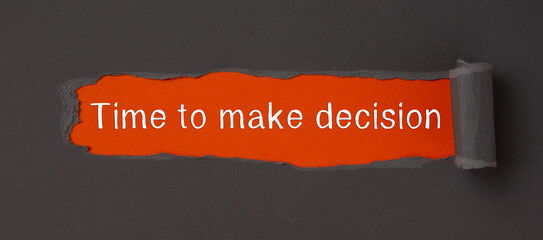 Time to make decision - appearing behind torn paper