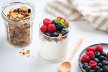 Greek yogurt with granola and berries in a jar. Healthy dessert, breakfast or snack