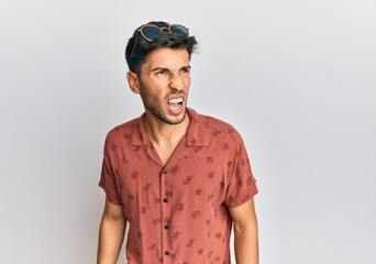 Young handsome man wearing casual summer clothes angry and mad screaming frustrated and furious, shouting with anger. rage and aggressive concept.
