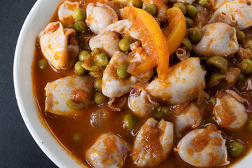 mini squid in tomato sauce with green peas and olives. Moroccan cuisine