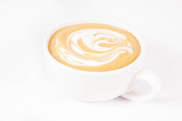 Pumpkin soup decorated with cream in a bowl on a white background