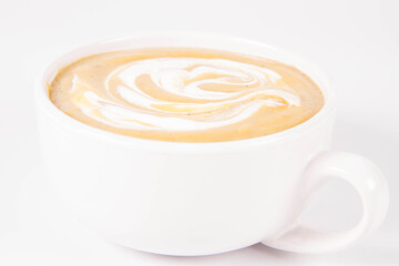 Pumpkin soup decorated with cream in a bowl on a white background