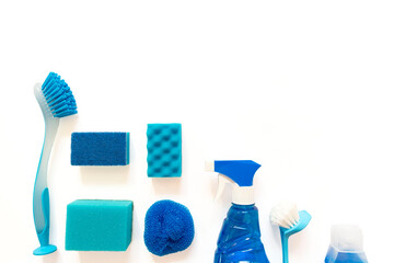 Blue cleaning kit. Bottles, spray, brushes, sponges flat lay on the white background with copy space