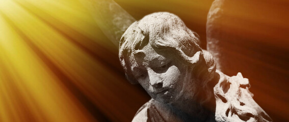 God’s angel of peace in the sunlight. Antique stone statue.