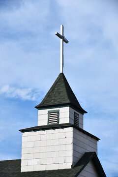 An image of an old wooden cross on a church steeple. 