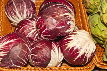 Fototapeta premium top view, medium distance of a pile of freshly picked, local ripe red cabbages, on display and for sale at a tropical food store