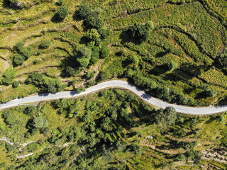 Aerial view of a road through the the mountains. Bird eye view taken through a drone