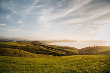 sunset from a hill with the sea in the background