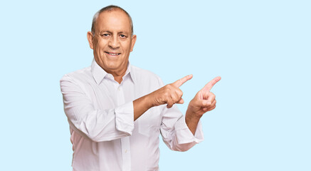 Handsome senior man wearing elegant white shirt smiling and looking at the camera pointing with two hands and fingers to the side.
