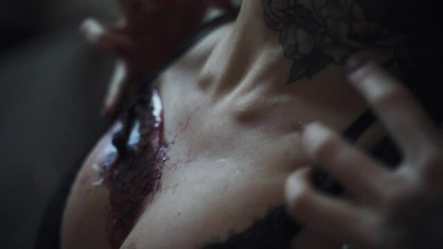 Female breast with lacerated bloody wound. Zombie image for halloween