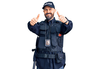 Young handsome man wearing police uniform approving doing positive gesture with hand, thumbs up smiling and happy for success. winner gesture.