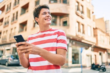 Fototapeta na wymiar Young caucasian man smiling happy using smartphone at the city.