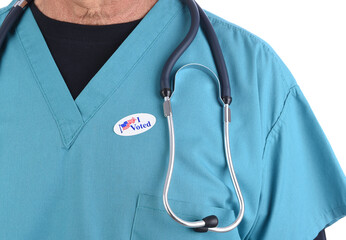 Closeup of a doctor with an I Voted sticker on his surgical scrubs