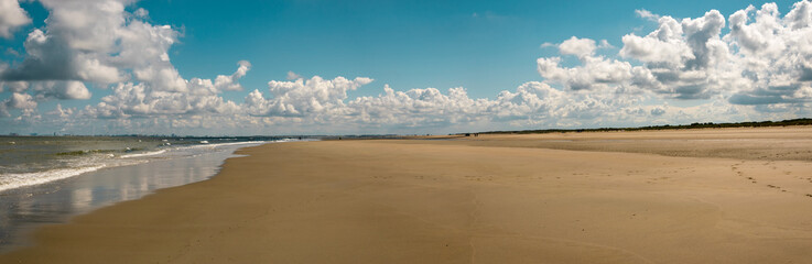 Fototapeta na wymiar Panoramic beach view with clouds Zeeland the Netherlands