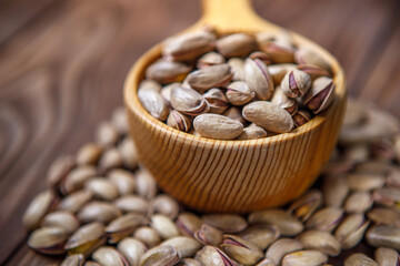 Pistachios in a Cup on a wooden background.  Place for text. Nuts close up