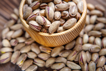 Pistachios in a Cup on a wooden background.  Place for text. Nuts close up