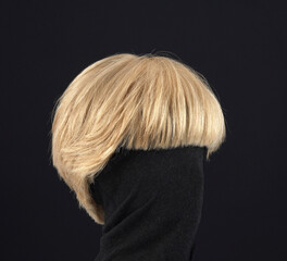 Blonde hair wig with bob cut, side view, black background