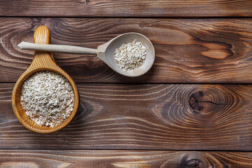 Wooden Cup and spoon with oatmeal. The concept of healthy eating. Wood texture. Flat layout. Copy space