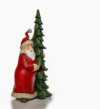 Ceramic Santa Claus with Christmas tree in his arms isolated