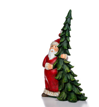 Ceramic Santa Claus with Christmas tree in his arms isolated