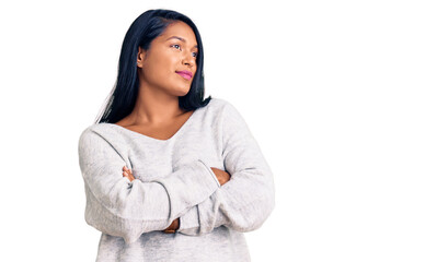 Hispanic woman with long hair wearing casual clothes looking to the side with arms crossed convinced and confident